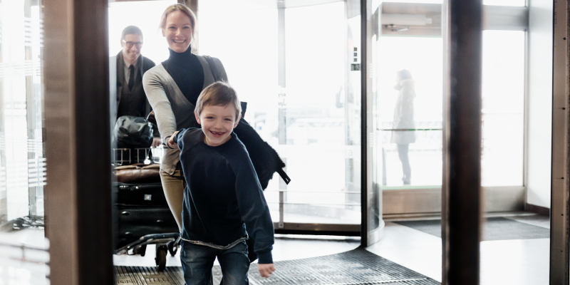 Pojke håller kvinna i handen vid ingången till terminal på Arlanda Pojke håller kvinna i handen vid ingången till terminal på Arlanda