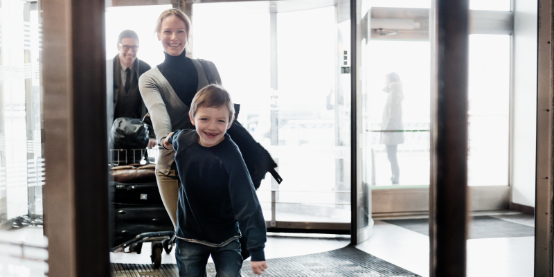 Pojke håller kvinna i handen vid ingången till terminal på Arlanda Pojke håller kvinna i handen vid ingången till terminal på Arlanda